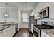 Modern kitchen with granite countertops, stainless steel appliances, and white cabinets at 2329 Village Grove Dr, Suwanee, GA 30024