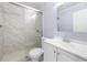 Modern bathroom with a glass shower, white vanity, and marble tile at 2666 Frontier Trl, Atlanta, GA 30341