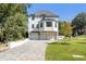 Two-story white house with three-car garage and landscaped lawn at 464 Pine Tree Ne Dr, Atlanta, GA 30305