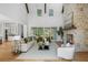 Bright living room boasts stone fireplace, wood beams, and windows offering a view of the landscaped yard at 464 Pine Tree Ne Dr, Atlanta, GA 30305