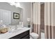 Well-lit bathroom featuring a modern vanity, sleek faucet, decorative mirror, and shower/tub with elegant shower curtain at 532 Barlow Pl, Grayson, GA 30017