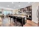 Modern kitchen with an island, bar stools, and stainless steel appliances overlooking a dining area at 532 Barlow Pl, Grayson, GA 30017