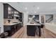 Stylish kitchen featuring dark cabinetry, modern appliances, large island and hardwood floors at 532 Barlow Pl, Grayson, GA 30017