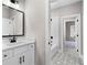 Bright bathroom featuring white vanity, black matte fixtures, and patterned floor at 208 Pindos Sw Pl, Powder Springs, GA 30127