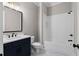 Modern bathroom with navy vanity, white subway tile, and bathtub at 208 Pindos Sw Pl, Powder Springs, GA 30127