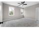 Spacious bedroom with grey carpet, ceiling fan, and two large windows at 208 Pindos Sw Pl, Powder Springs, GA 30127