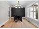 Elegant dining room with hardwood floors, chandelier, and a dark accent wall at 208 Pindos Sw Pl, Powder Springs, GA 30127