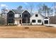 Two-story farmhouse-style home with white and black exterior, and landscaping at 208 Pindos Sw Pl, Powder Springs, GA 30127