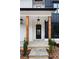 Modern farmhouse front entrance with black door, wood columns, and stone patio at 208 Pindos Sw Pl, Powder Springs, GA 30127