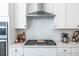 Modern white kitchen with stainless steel appliances and gas cooktop at 2487 Figaro Dr, Atlanta, GA 30339