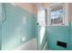 Bathroom with light blue tile, shower, and window at 2833 Alan Sw Dr, Marietta, GA 30064