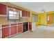 Kitchen with wood cabinets and yellow walls at 5662 Grist Stone Sw Dr, Lilburn, GA 30047