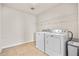 Bright laundry room with washer, dryer, and overhead shelving at 4745 Billow Sw Way, Mableton, GA 30126