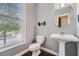 Powder room features pedestal sink, window, and dark wood floors at 9972 Ashton Old Rd, Douglasville, GA 30135