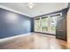 Bright bedroom with hardwood floors, dark blue walls, and access to an outdoor patio at 9972 Ashton Old Rd, Douglasville, GA 30135