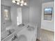 Clean bathroom with double sinks, a large mirror, and a window at 220 Mountain Way, Covington, GA 30016
