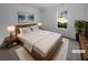 Virtually staged main bedroom with a king-size bed, wood nightstands, and large window at 220 Mountain Way, Covington, GA 30016
