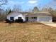 Charming one-story house with a white exterior, covered porch, and attached garage at 220 Mountain Way, Covington, GA 30016