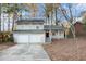 Two-story house with beige siding, attached double garage, and mature trees at 3901 W Wood Path, Stone Mountain, GA 30083
