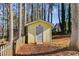 Yellow storage shed with grey door in backyard at 1094 Plantation Ct, Villa Rica, GA 30180