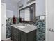 Stylish bathroom with decorative mirror, gray vanity, mosaic wall, and neutral countertops at 2510 Cumberland Se Ct, Smyrna, GA 30080