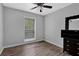 Cozy bedroom featuring a ceiling fan, hardwood floors, and ample natural light from the window at 2510 Cumberland Se Ct, Smyrna, GA 30080