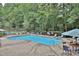 View of the community swimming pool and tennis court surrounded by mature trees at 2510 Cumberland Se Ct, Smyrna, GA 30080