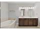 Bathroom featuring double vanity sinks, soaking tub, and tile surround at 4382 Benfield Se Way, Smyrna, GA 30080