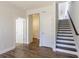 Hallway with hardwood floors, staircase with wood railing, and multiple doors leading to various rooms, showcasing the home's layout at 4382 Benfield Se Way, Smyrna, GA 30080