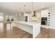 Spacious open kitchen with white cabinetry, large island, stainless steel appliances, and modern pendant lights at 4382 Benfield Se Way, Smyrna, GA 30080