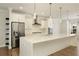 A closer view of the kitchen featuring a waterfall island, pendant lighting, and modern appliances at 4382 Benfield Se Way, Smyrna, GA 30080