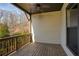 Covered porch with ceiling fan, wood railing, and serene view of surrounding trees at 4382 Benfield Se Way, Smyrna, GA 30080