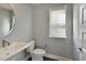 Modern powder room featuring a pedestal sink and a round mirror at 4382 Benfield Se Way, Smyrna, GA 30080