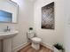 Small half-bathroom with pedestal sink and art at 1822 Emory Ln # 89, Conyers, GA 30013