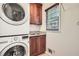 Laundry room with stacked LG washer and dryer, and wooden cabinets at 1276 Hickory Sw Dr, Lilburn, GA 30047