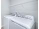 Bright laundry room, featuring washer and dryer and overhead shelving at 2058 Dickons Garden Ln, Mcdonough, GA 30253