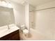 Bathroom featuring a shower-tub combo, white tiling, and a dark vanity at 1055 Grove Valley Dr, Cumming, GA 30041