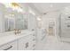 Elegant bathroom with double vanity, marble floors, and a glass shower at 115 N Devereux Nw Ct, Atlanta, GA 30327