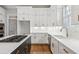 Modern kitchen with white cabinets, quartz countertops and island with gas cooktop at 115 N Devereux Nw Ct, Atlanta, GA 30327