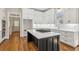 Modern kitchen with white cabinets, quartz countertops and island with gas cooktop at 115 N Devereux Nw Ct, Atlanta, GA 30327