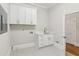 Convenient laundry room with white cabinets and patterned floor at 115 N Devereux Nw Ct, Atlanta, GA 30327