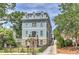 Three-story home with stone and blue siding, a driveway, and a landscaped front yard at 2972 Lookout Ne Pl, Atlanta, GA 30305