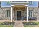 Front entrance with stone details, black door, and a brick walkway at 2972 Lookout Ne Pl, Atlanta, GA 30305