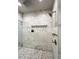 Walk-in shower with marble tile, multiple shower heads, and built-in seat at 2972 Lookout Ne Pl, Atlanta, GA 30305