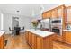 Well-lit kitchen with a center island, stainless steel appliances, and hardwood floors at 2317 Saint Davids Nw Sq, Kennesaw, GA 30152