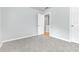 Bright bedroom with gray carpet and door to hallway at 526 Bass Pointe Nw, Kennesaw, GA 30144