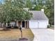 Brick front house with a two-car garage and mature trees at 526 Bass Pointe Nw, Kennesaw, GA 30144