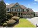 Two-story house with stone accents, 3-car garage, and manicured lawn at 5585 Lavender Farms Rd, Powder Springs, GA 30127