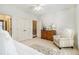 Bedroom with white bedding, wooden dresser, and armchair at 2082 Greenway Mill Ct, Snellville, GA 30078