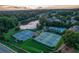 Well-maintained tennis courts with surrounding landscape and a community pool in the background at 2082 Greenway Mill Ct, Snellville, GA 30078